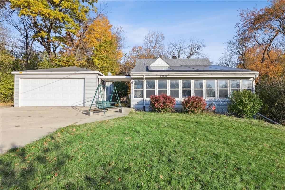 a view of a house with backyard and a tree