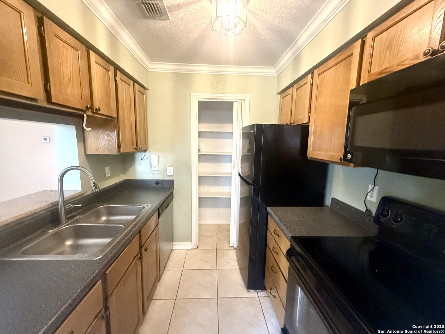 13018 Heimer, Unit 703 San Antonio, TX 78216 - Photo 11 of 28 a kitchen with granite countertop a refrigerator and a sink