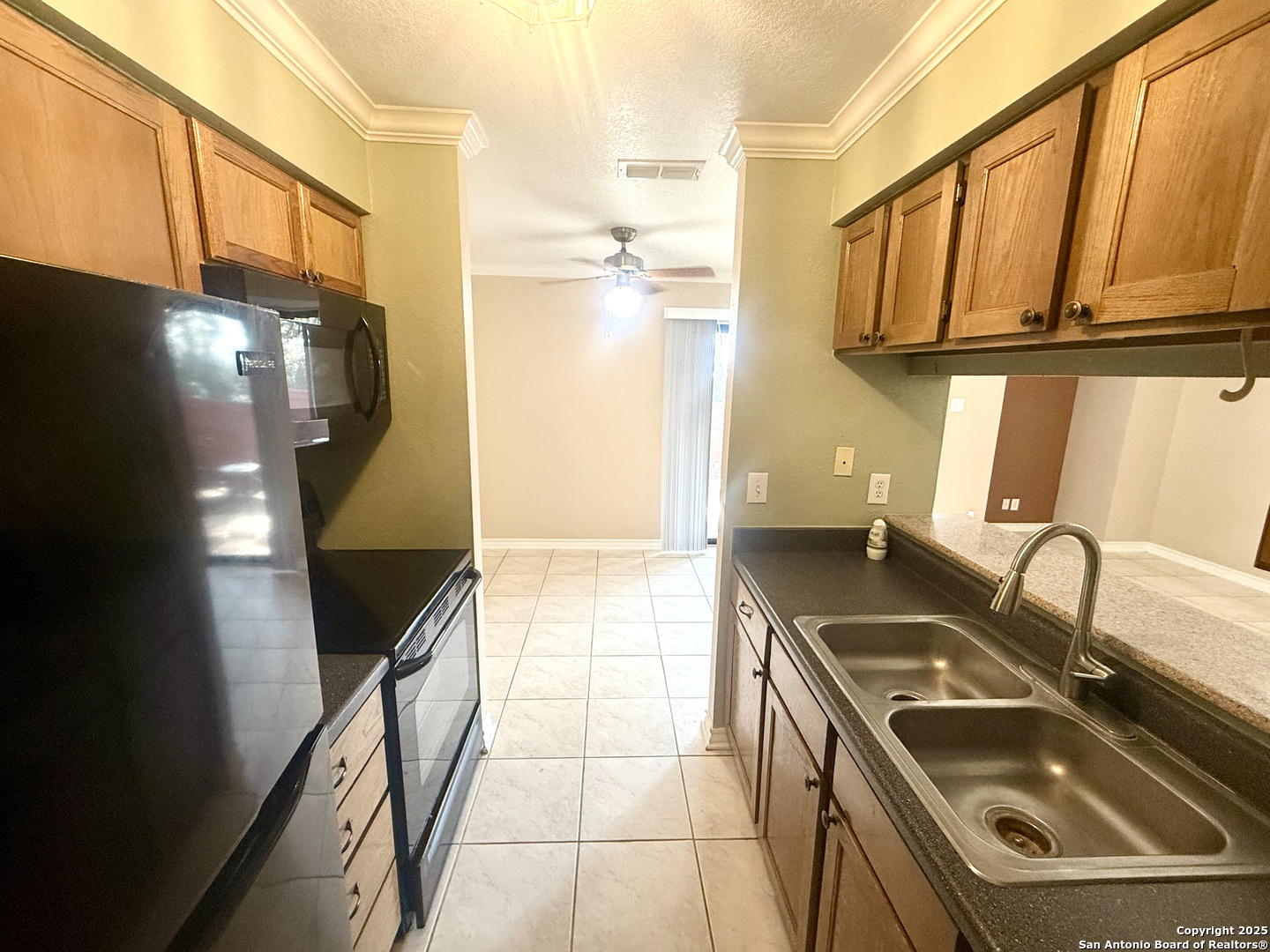13018 Heimer, Unit 703 San Antonio, TX 78216 - Photo 12 of 28 a kitchen with a sink a refrigerator and cabinets