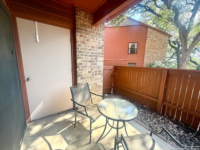 a backyard of a house with table and chairs