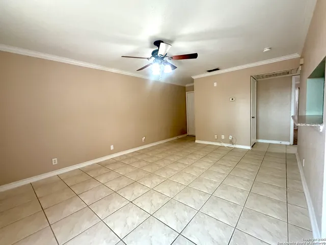 a view of an empty room with closet and a chandelier fan