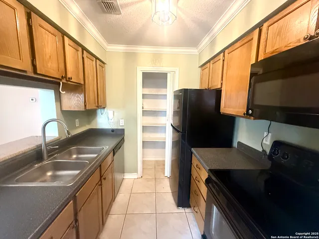 a kitchen with a sink a refrigerator and cabinets