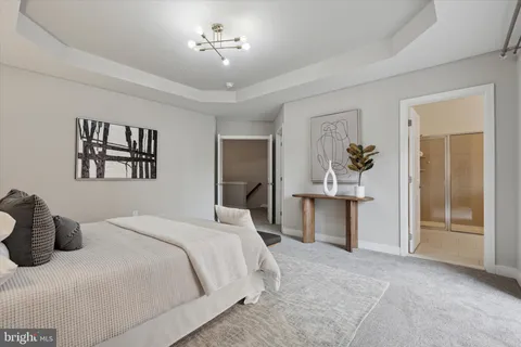 a bedroom with a large bed and a chandelier