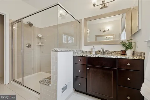 a bathroom with a sink vanity and shower
