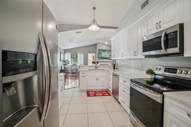 a kitchen with cabinets stainless steel appliances and a counter space