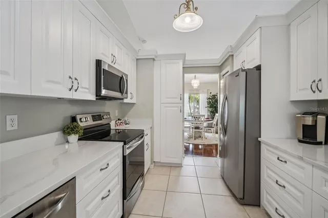 a kitchen with white cabinets and stainless steel appliances