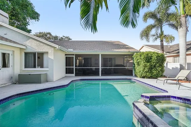 a view of a white house with a swimming pool and sitting area