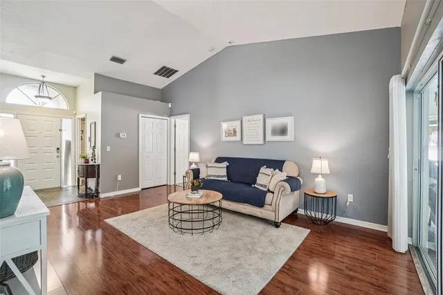a living room with furniture and a wooden floor