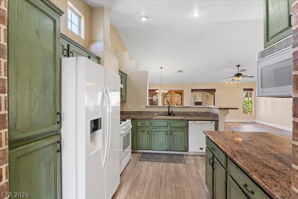120 Ringlore Road Henderson, NV 89015 - Photo 16 of 58 Gleaming stone countertops and rustic green cabinetry define this open kitchen design.