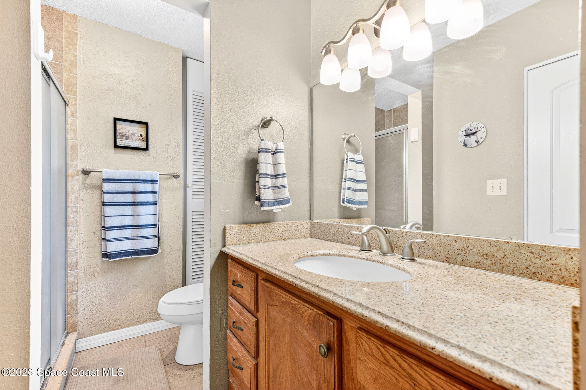 1857 North Carpenter Road Titusville, FL 32796 - Photo 19 of 51 a bathroom with a granite countertop sink mirror vanity and toilet