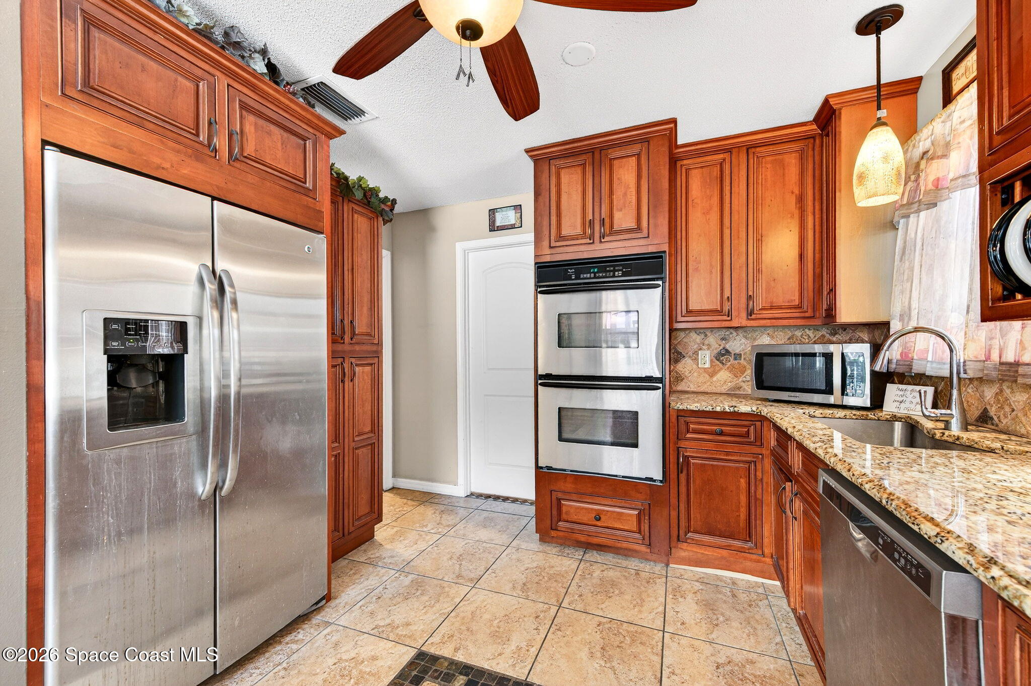 1857 North Carpenter Road Titusville, FL 32796 - Photo 6 of 51 a kitchen with stainless steel appliances granite countertop a refrigerator and a sink