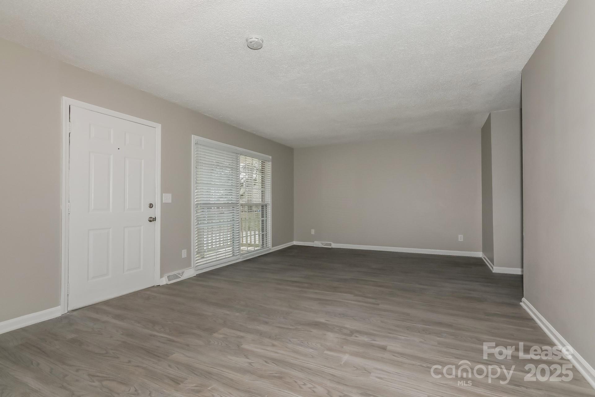 319 Cedarwood Lane Matthews, NC 28104 - Photo 3 of 16 a view of an empty room with wooden floor and a window