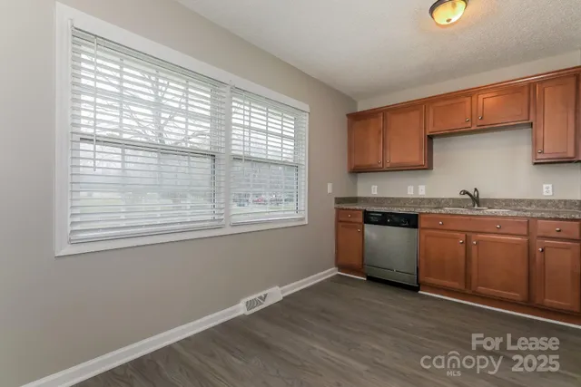 a kitchen with granite countertop a stove a sink and a microwave