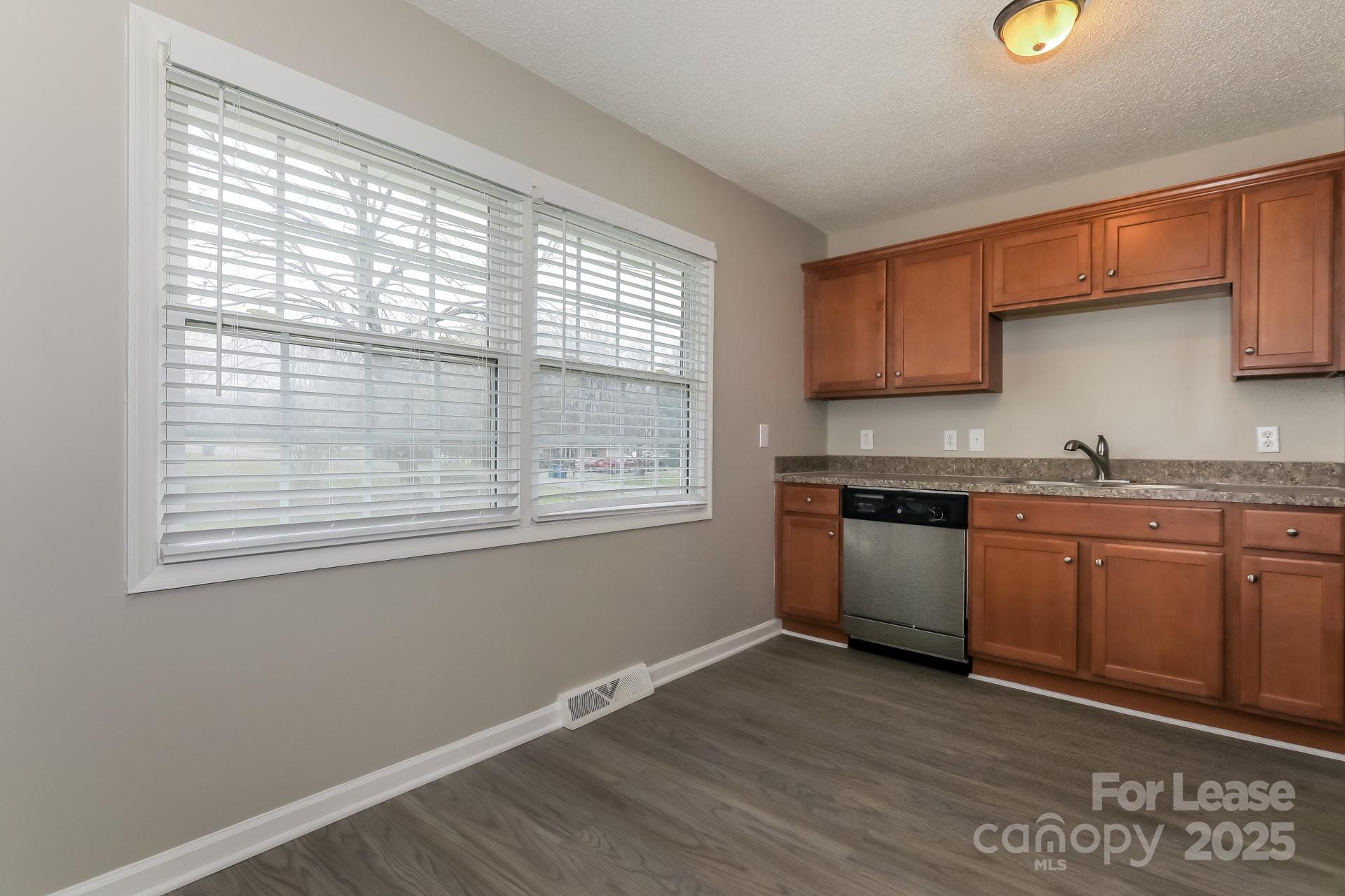 319 Cedarwood Lane Matthews, NC 28104 - Photo 6 of 16 a kitchen with granite countertop a stove a sink and a microwave