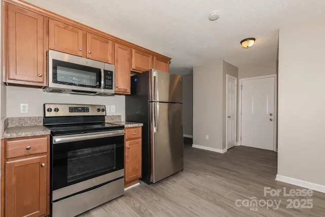 a kitchen with granite countertop a refrigerator stove and microwave