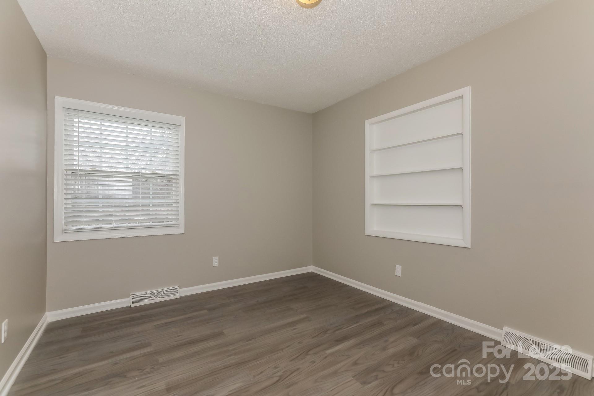 319 Cedarwood Lane Matthews, NC 28104 - Photo 9 of 16 a view of an empty room with wooden floor and a window
