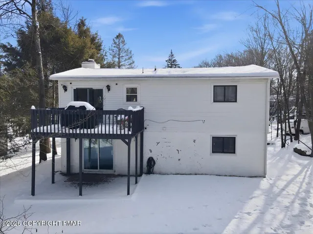 a front view of a house with a yard covered in snow