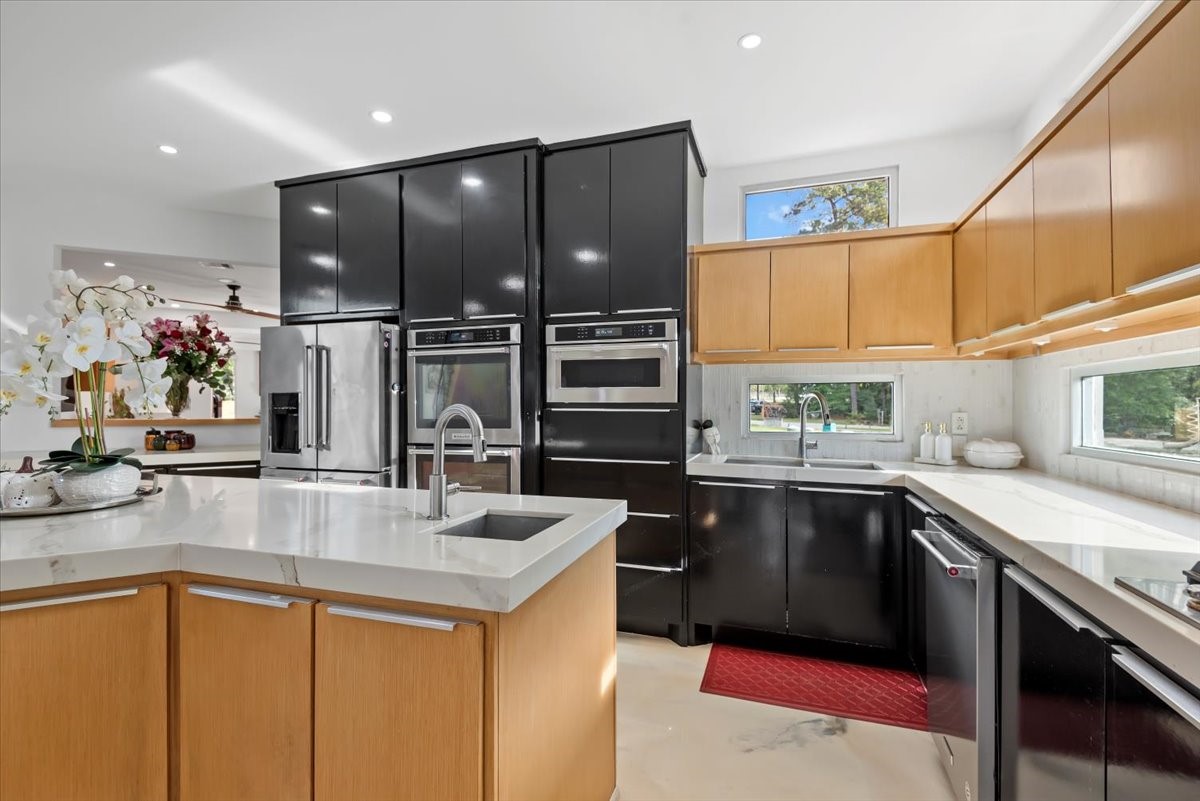 30400 Highland Boulevard Magnolia, TX 77354 - Photo 20 of 50 a kitchen with stainless steel appliances granite countertop a sink a stove and a refrigerator