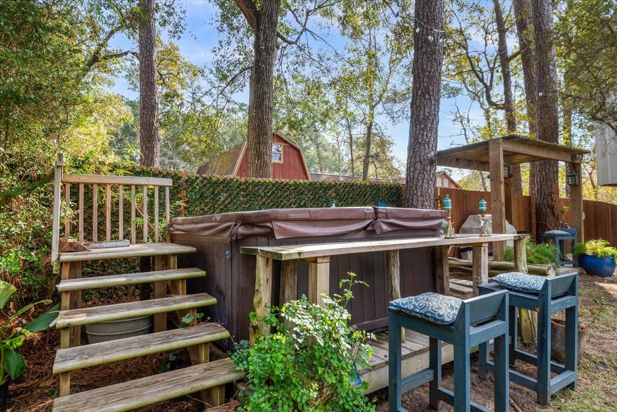 30400 Highland Boulevard Magnolia, TX 77354 - Photo 47 of 50 a view of a patio with table and chairs with wooden fence and plants