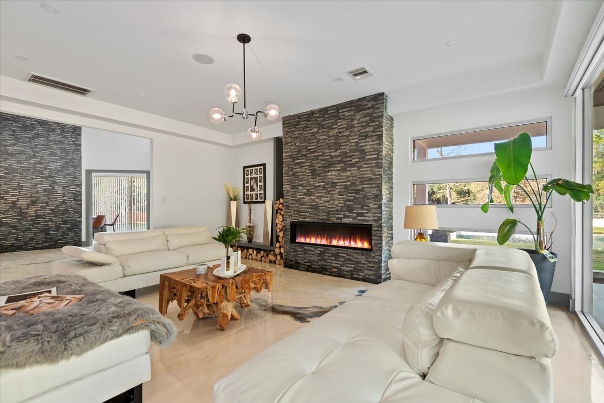 30400 Highland Boulevard Magnolia, TX 77354 - Photo 9 of 50 a living room with furniture a fireplace and a chandelier