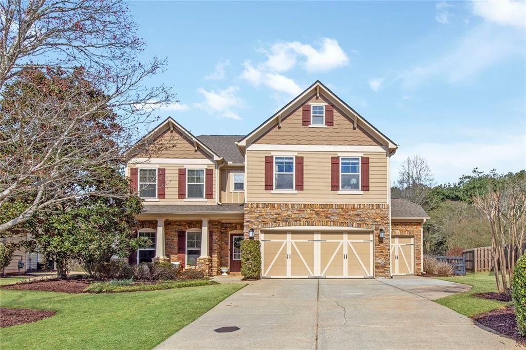 a front view of a house with a yard and trees