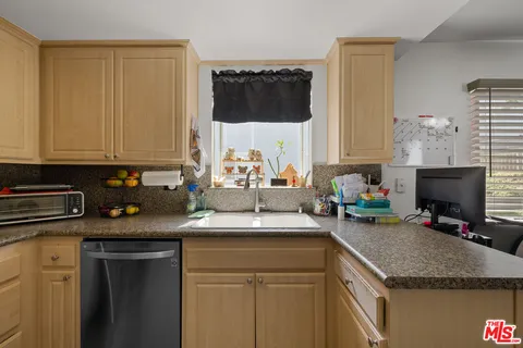 a kitchen with a sink a stove and cabinets