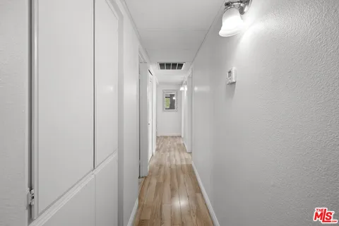 a view of a hallway with wooden floor