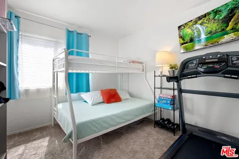 a bedroom with a bed a window and dresser