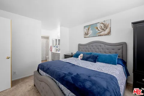 a bedroom with a bed and painting on the wall