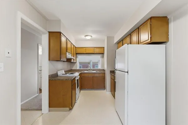 a kitchen with a refrigerator a stove top oven a sink and dishwasher