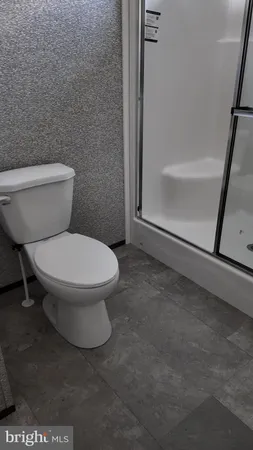 a white toilet sitting next to a bath tub