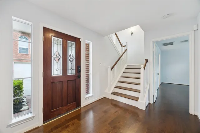 a view of a livingroom with wooden floor and stairs