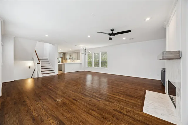 a view of a livingroom with wooden floor and a ceiling fan