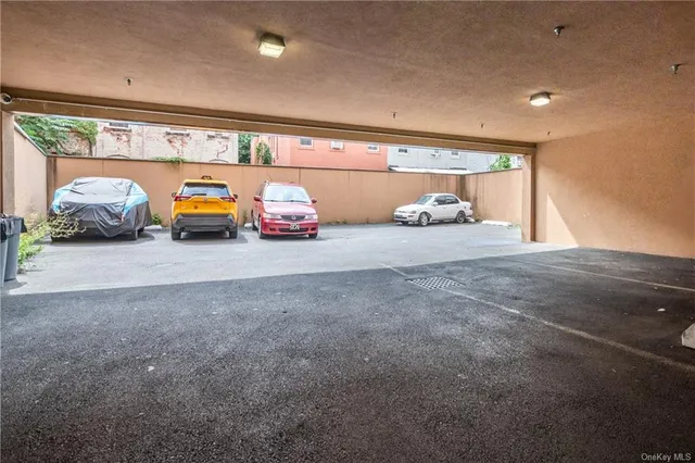 a view of an empty room with kitchen and window