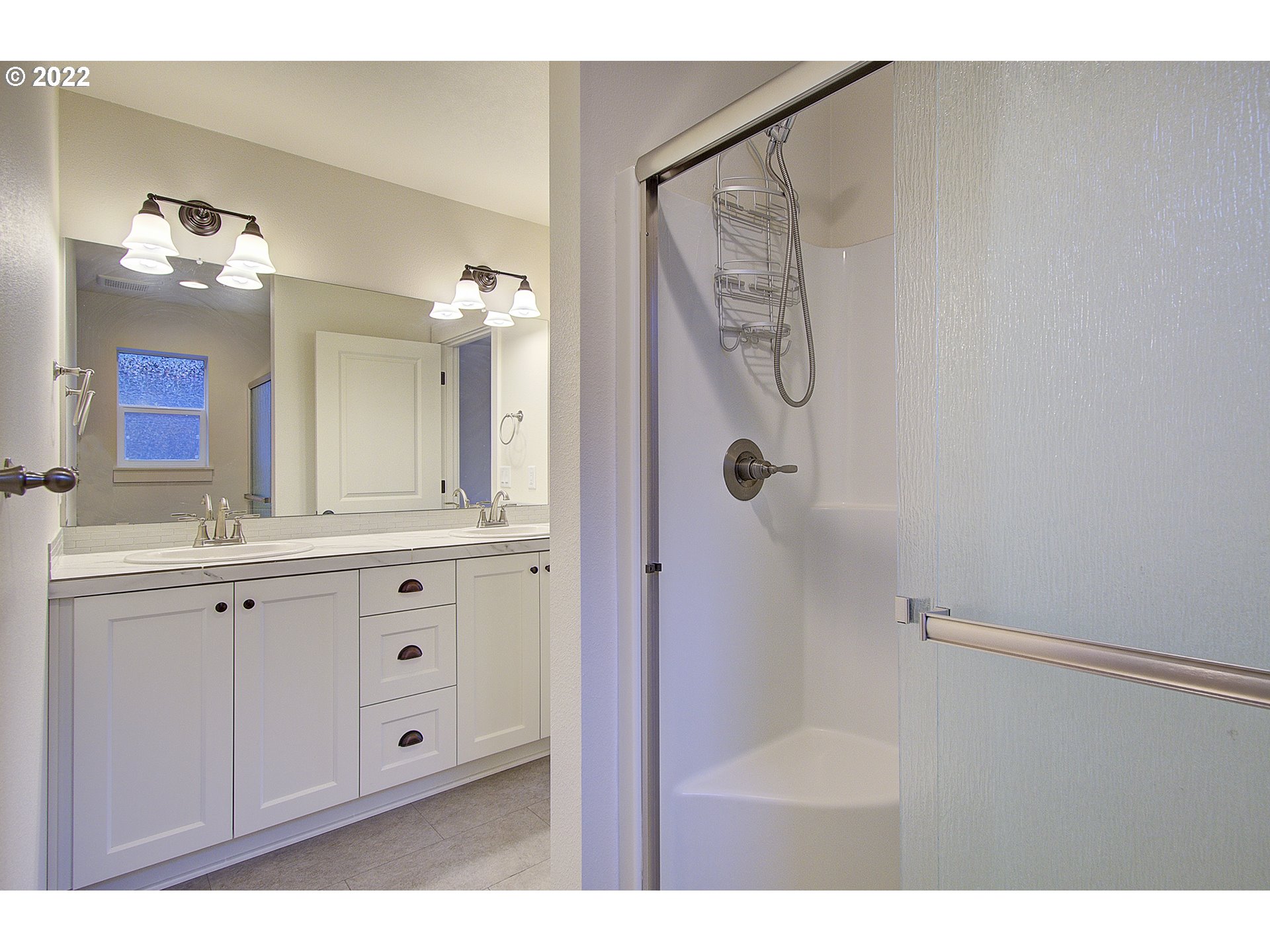 7107 South 11th Street Ridgefield, WA 98642 - Photo 13 of 26 a bathroom with a shower sink and mirror
