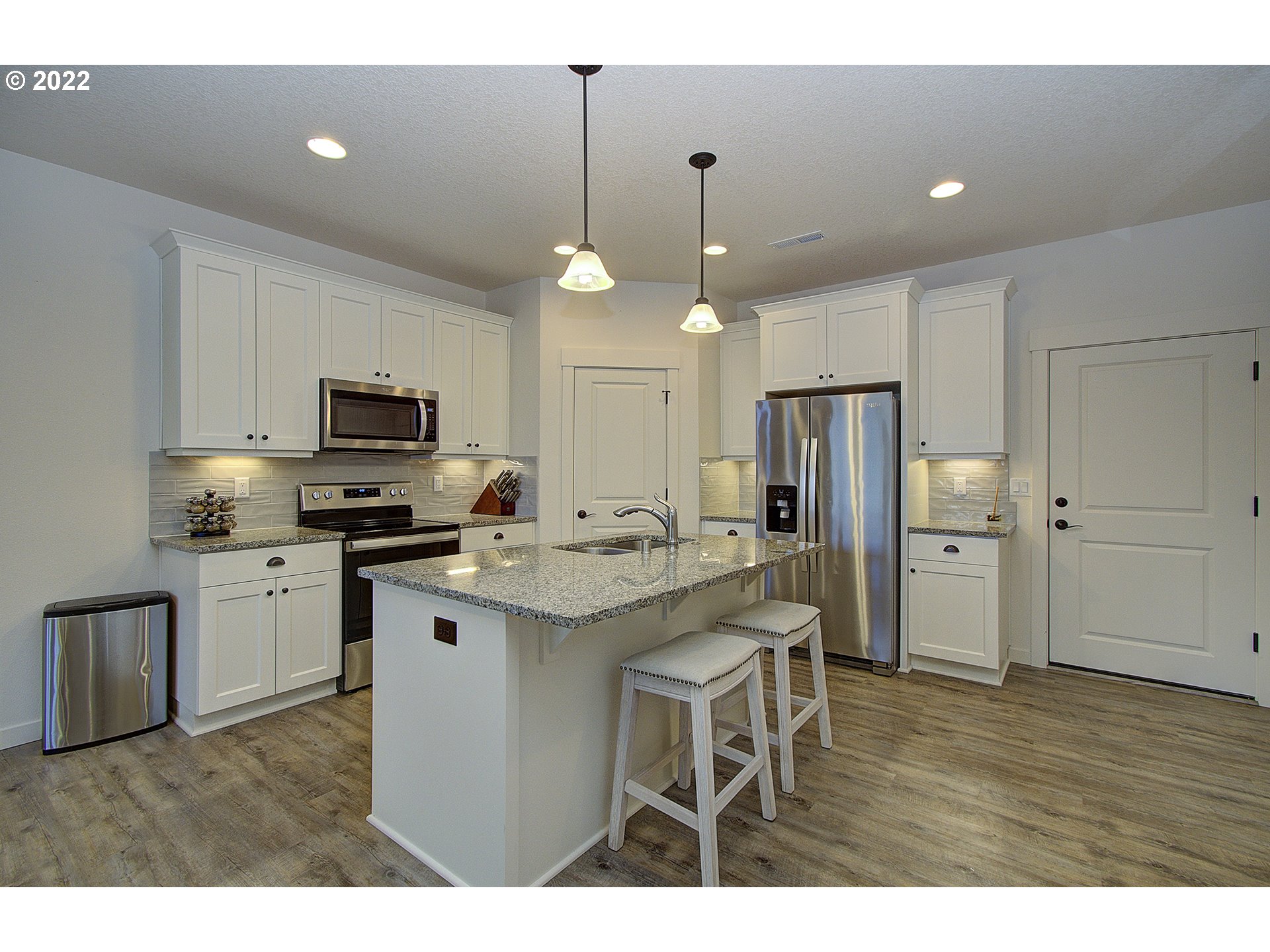 7107 South 11th Street Ridgefield, WA 98642 - Photo 5 of 26 a kitchen with white cabinets and stainless steel appliances