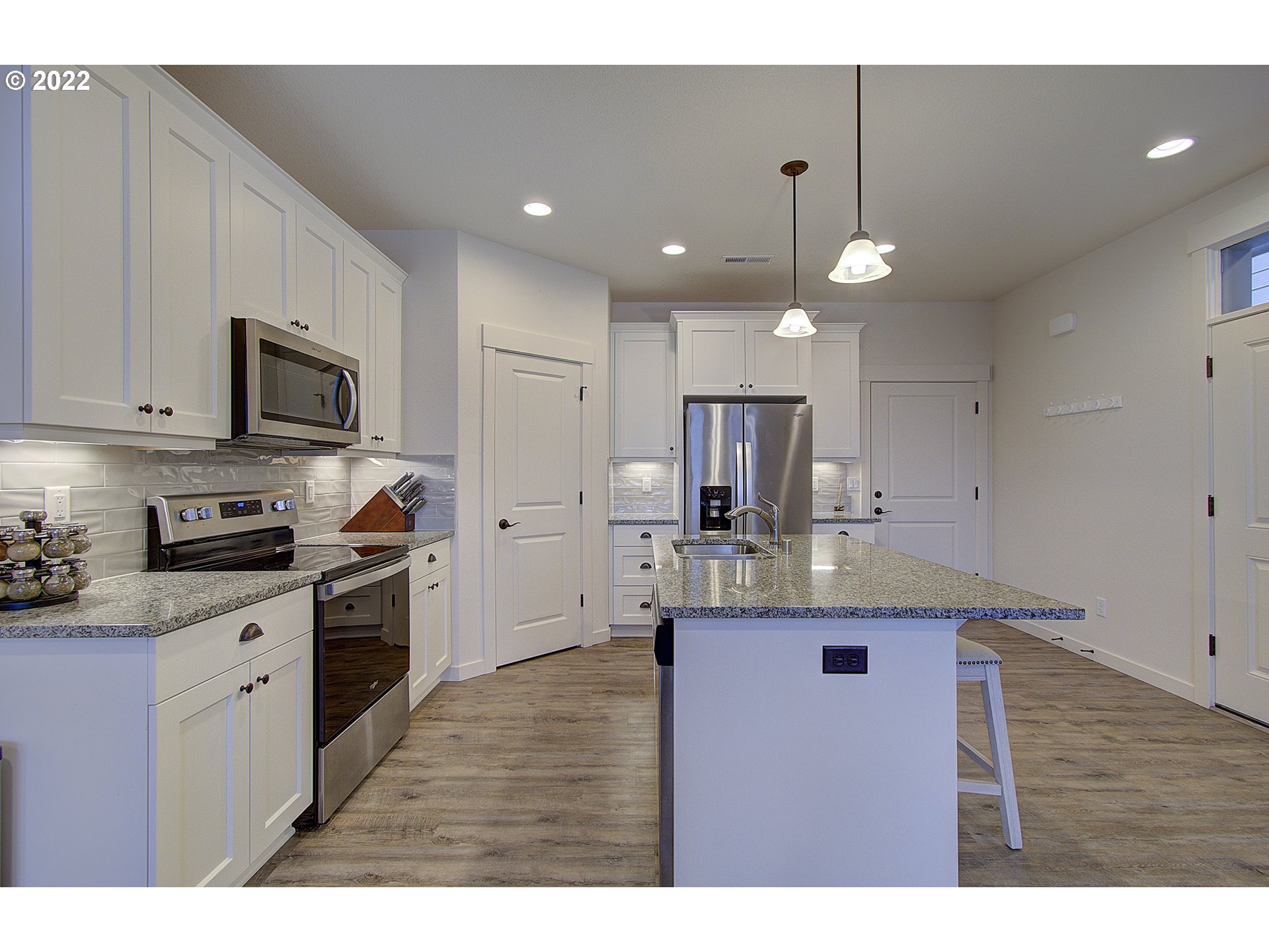 7107 South 11th Street Ridgefield, WA 98642 - Photo 6 of 26 a kitchen with kitchen island granite countertop a sink stainless steel appliances and cabinets