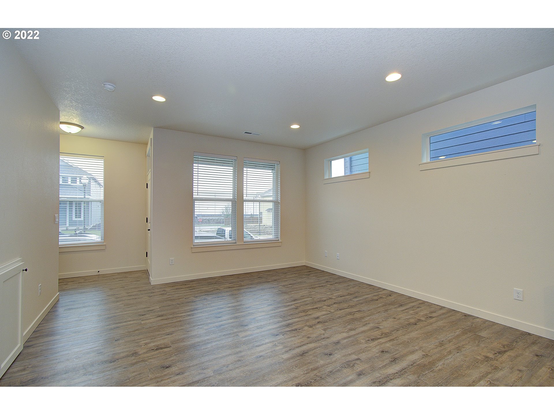 7107 South 11th Street Ridgefield, WA 98642 - Photo 8 of 26 a view of an empty room with wooden floor and a window