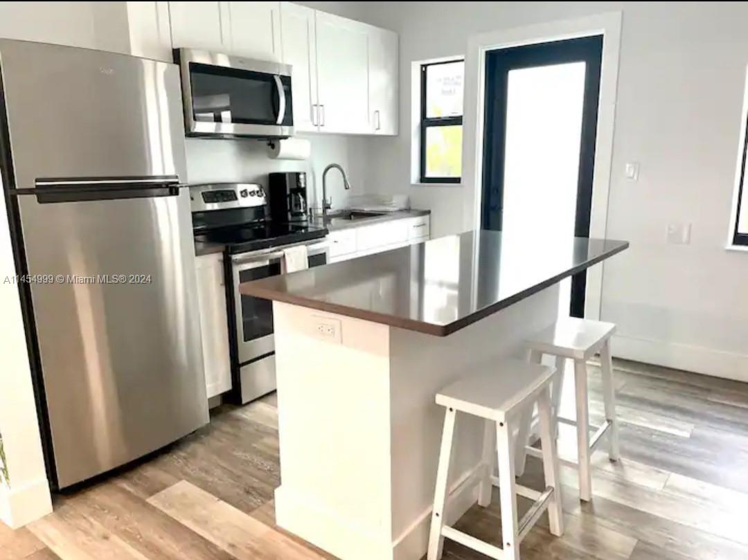 2141 Southwest 14th Terrace Miami, FL 33145 - Photo 11 of 47 a kitchen with stainless steel appliances a refrigerator a sink a stove a microwave and cabinets
