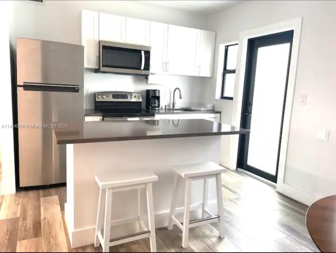 2141 Southwest 14th Terrace Miami, FL 33145 - Photo 22 of 47 a kitchen with cabinets and stainless steel appliances