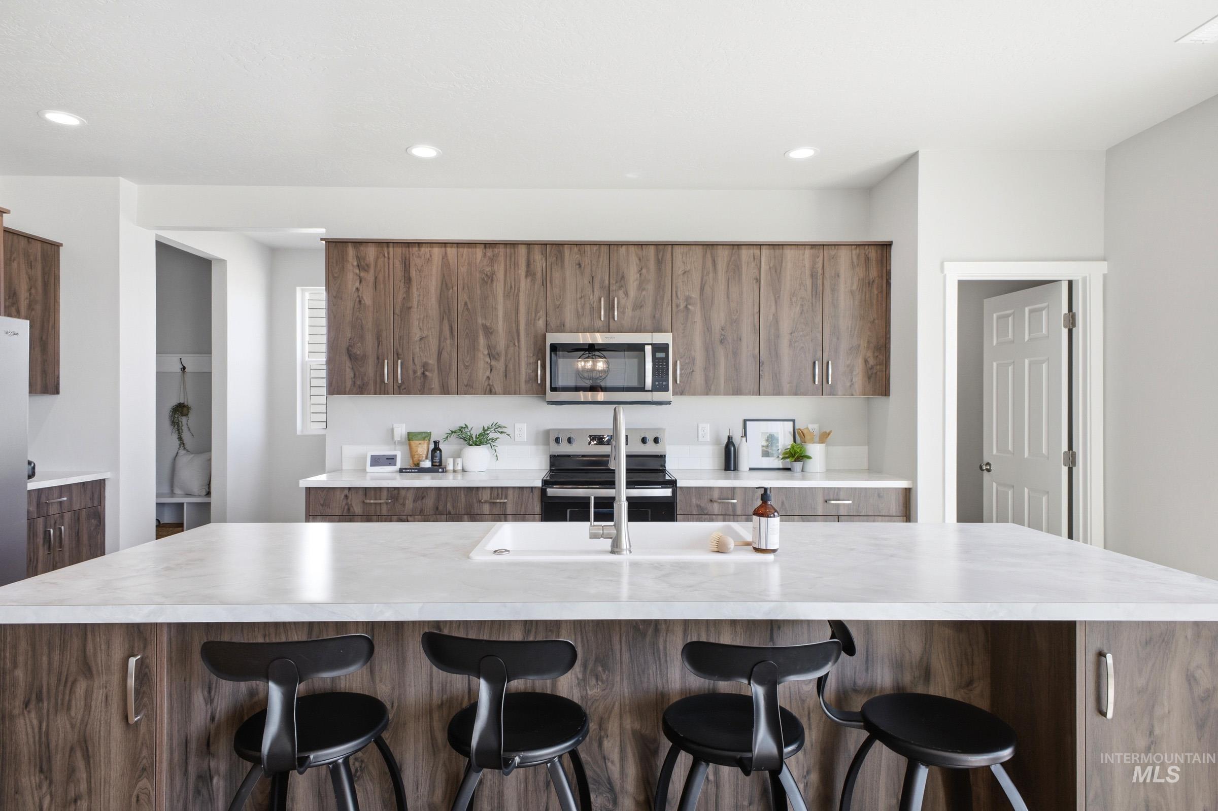 1645 Dyer Street Middleton, ID 83644 - Photo 13 of 31 Kitchen featuring a kitchen breakfast bar, stainless steel appliances, a center island with sink, modern cabinets, and wood finish cabinets
