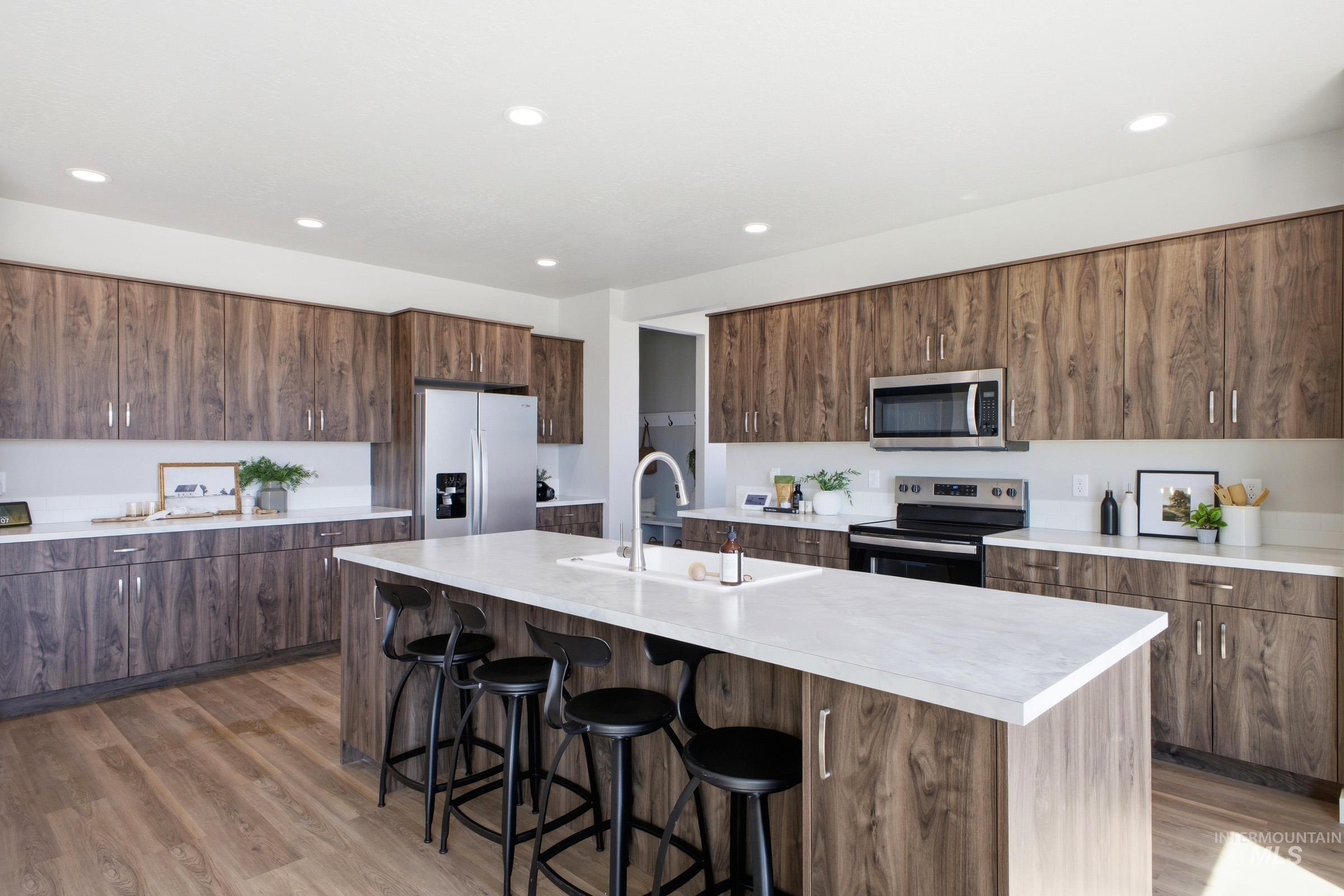 1645 Dyer Street Middleton, ID 83644 - Photo 17 of 31 Kitchen featuring modern cabinets, stainless steel appliances, light countertops, a breakfast bar, and a center island with sink