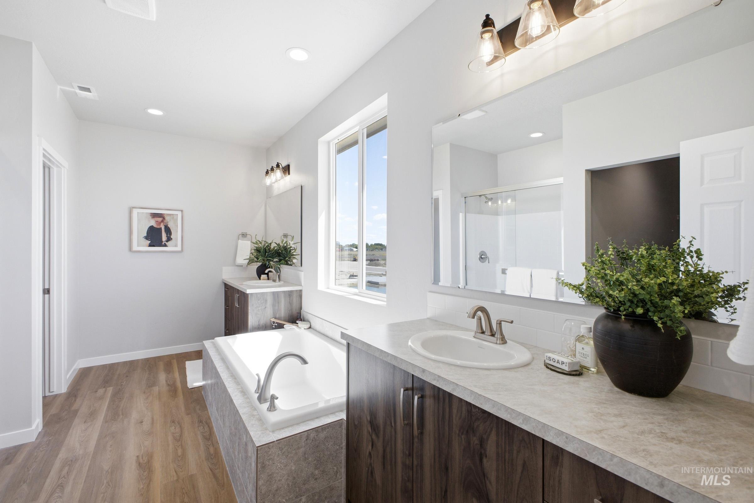 1645 Dyer Street Middleton, ID 83644 - Photo 25 of 31 Bathroom with two vanities, a stall shower, a garden tub, light wood finished floors, and recessed lighting