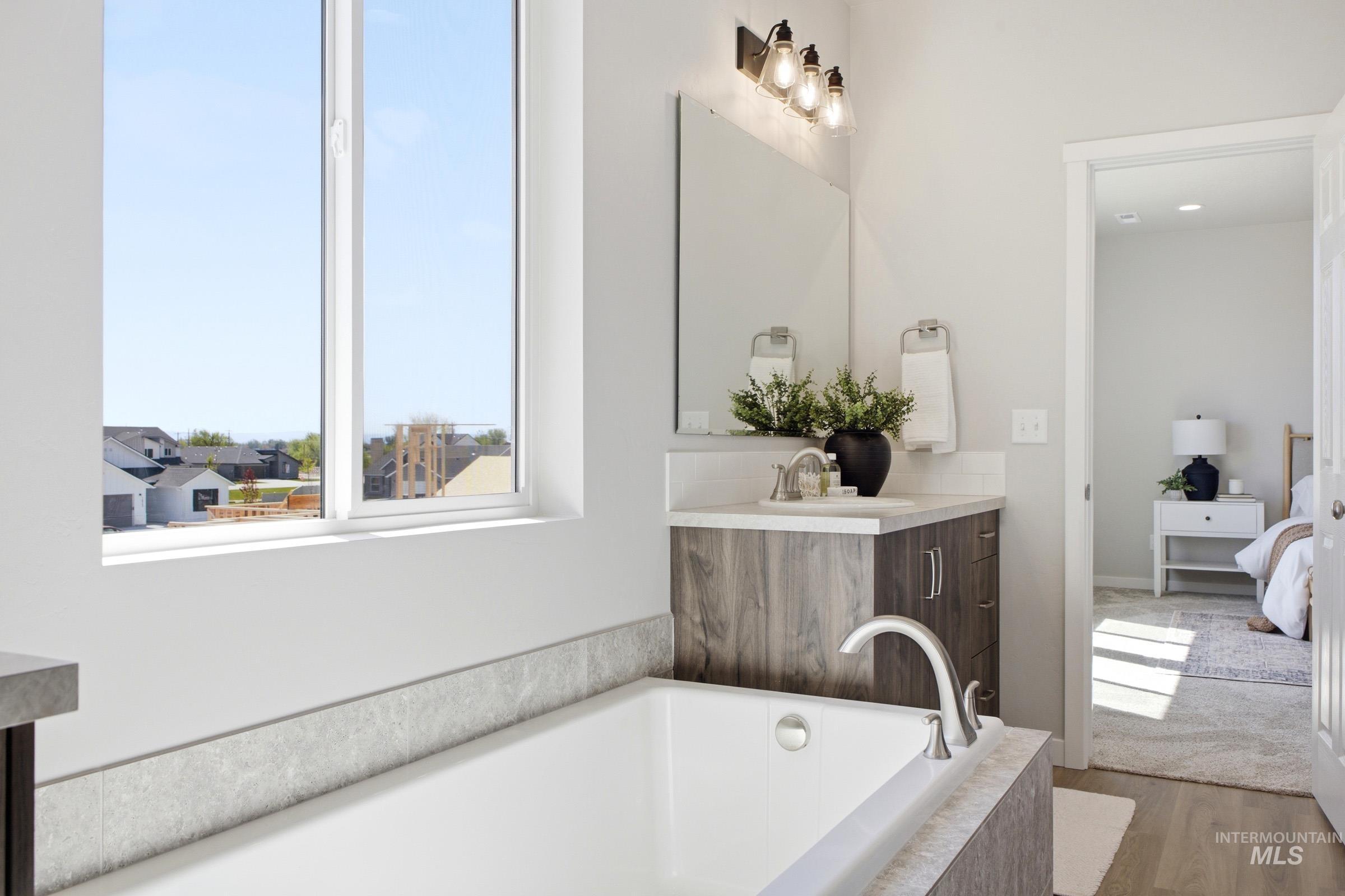 1645 Dyer Street Middleton, ID 83644 - Photo 27 of 31 Ensuite bathroom with vanity, a bath, and wood finished floors