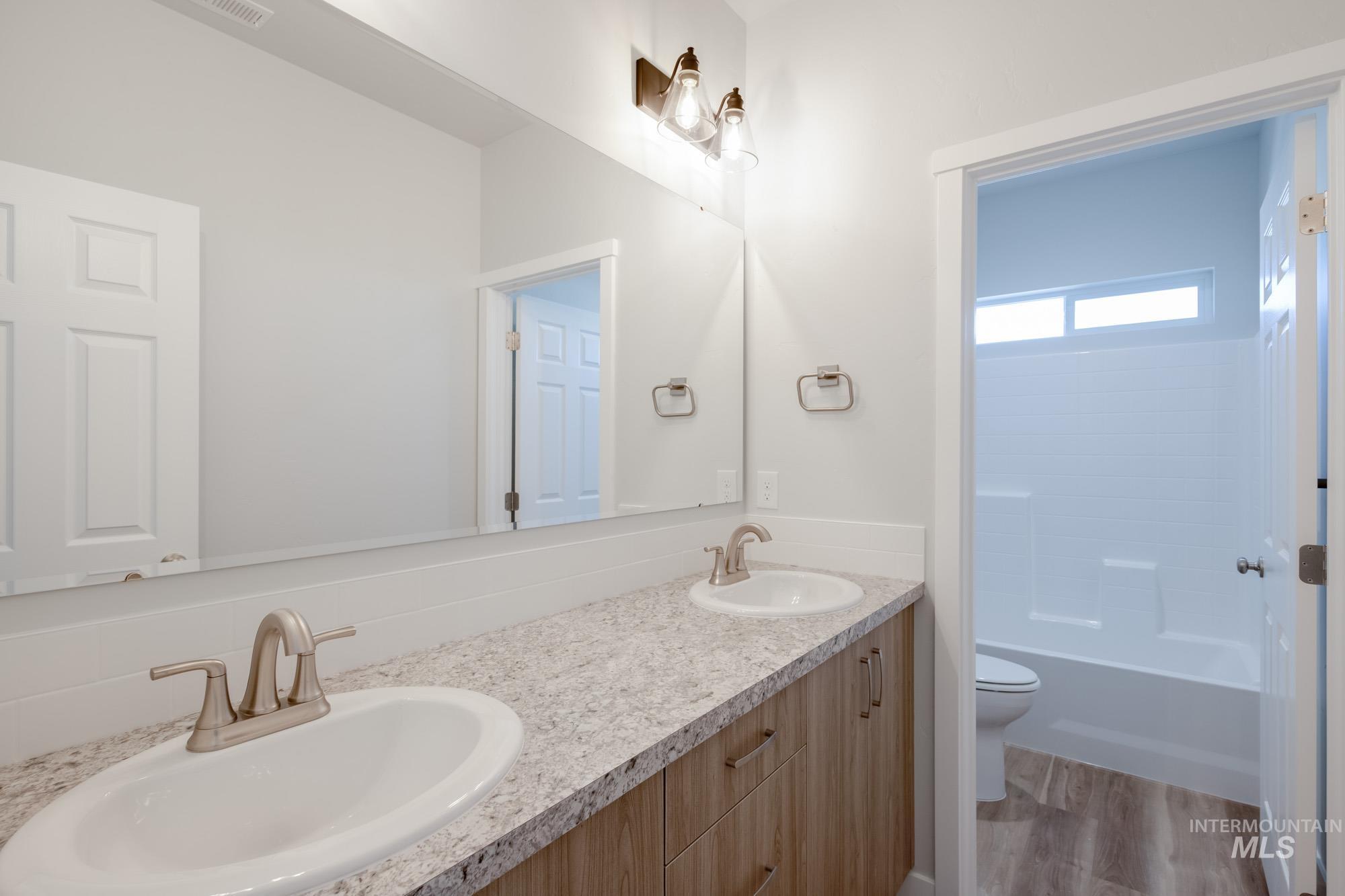 1645 Dyer Street Middleton, ID 83644 - Photo 32 of 32 Bathroom with double vanity, light wood finished floors, and bathtub / shower combination