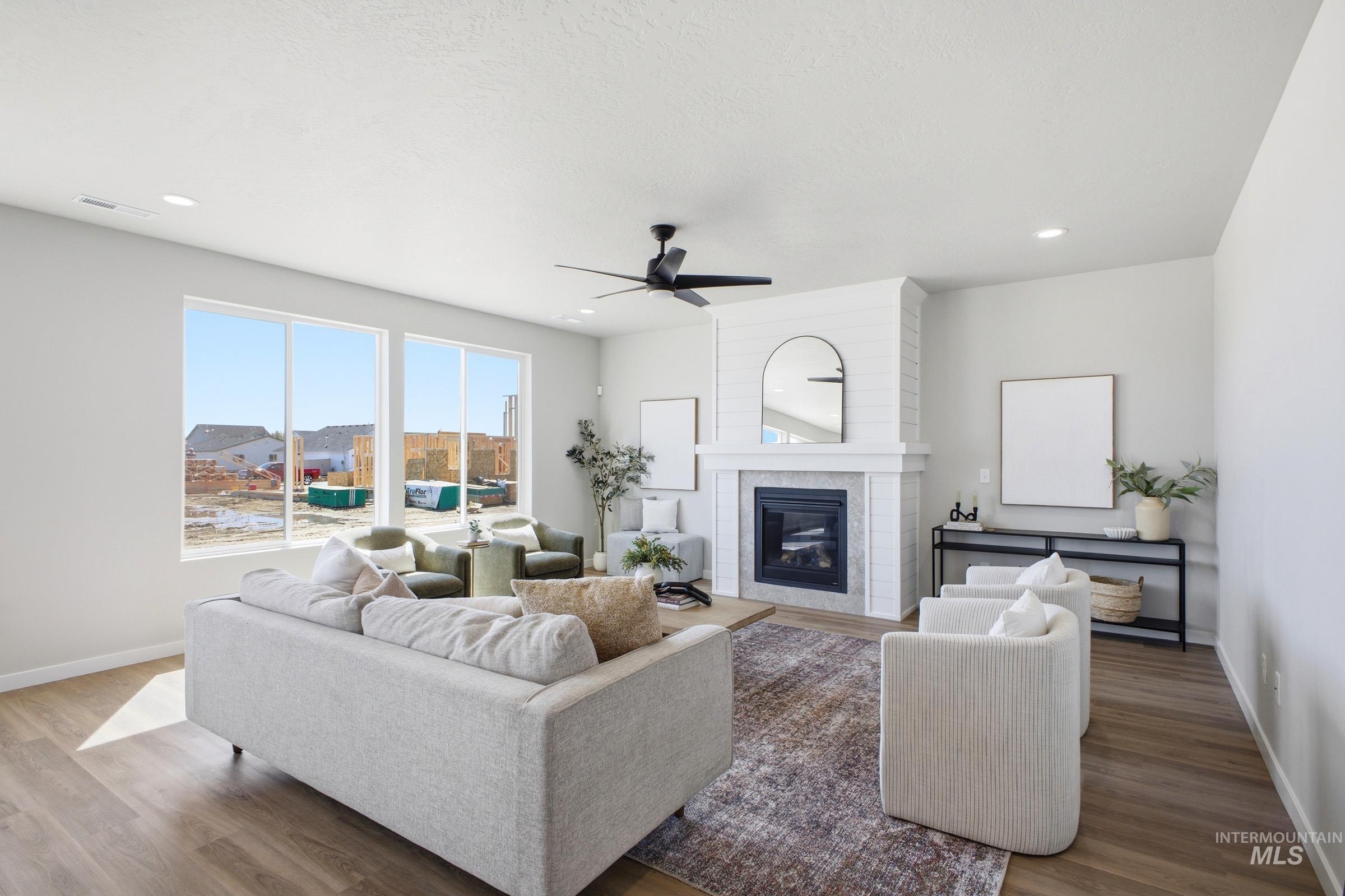 1645 Dyer Street Middleton, ID 83644 - Photo 5 of 31 Living area featuring a fireplace, a ceiling fan, and wood finished floors