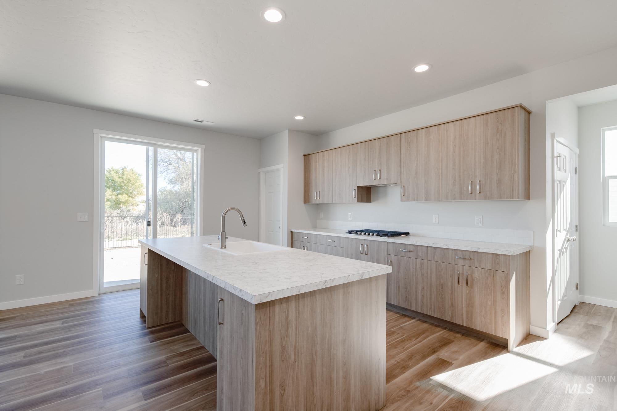 1645 Dyer Street Middleton, ID 83644 - Photo 8 of 32 Kitchen featuring light brown cabinets, light countertops, a center island with sink, light wood-style floors, and recessed lighting