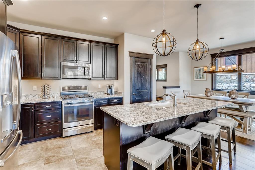 851 Independence Road, Unit 5A Keystone, CO 80435 - Photo 10 of 28 a kitchen with stainless steel appliances granite countertop wooden cabinets a stove a dining table and chairs