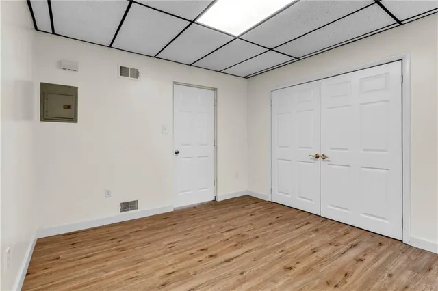 a view of empty room with wooden floor