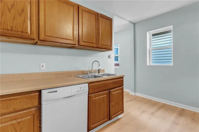 a kitchen with stainless steel appliances granite countertop a sink and cabinets with wooden floor